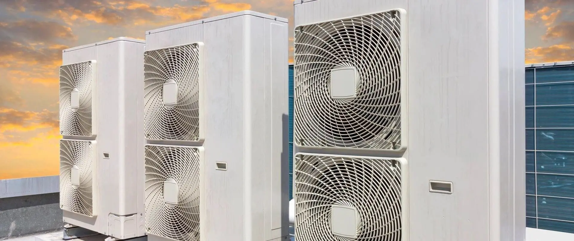 Multiple air conditioners are installed on the side of a building, positioned for efficient outdoor operation