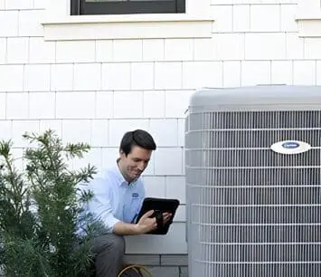 An AC repair technician is inspecting an air conditioner, assessing its condition for repairs or maintenance in Jacksonville