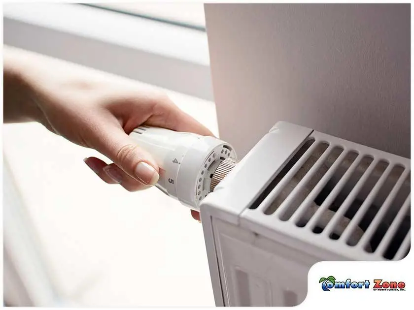 A person is holding an air conditioner in their hand.