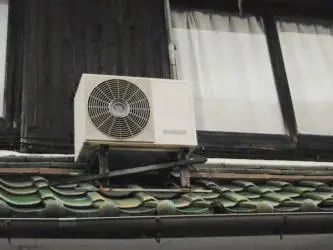 A small air conditioner on the side of a house.