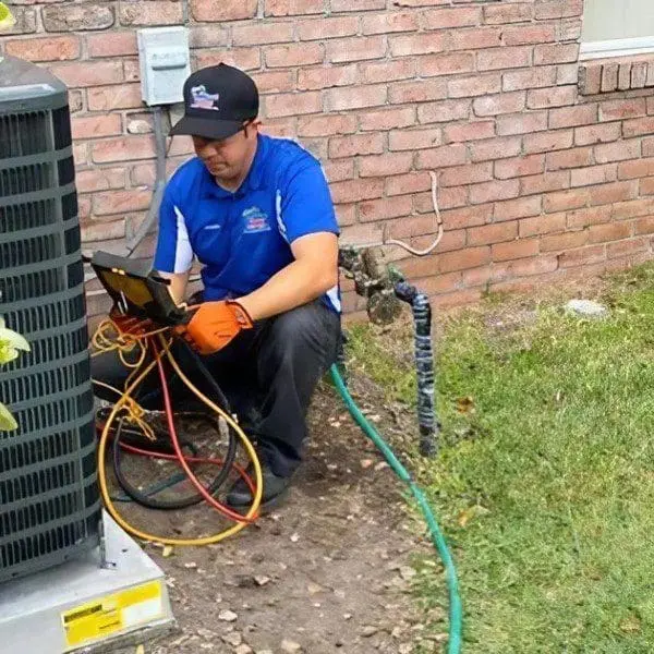 Comfort Zone of North Florida, Inc. An HVAC technician is working on a residential air conditioner outside, likely performing repairs or maintenance in Jacksonville