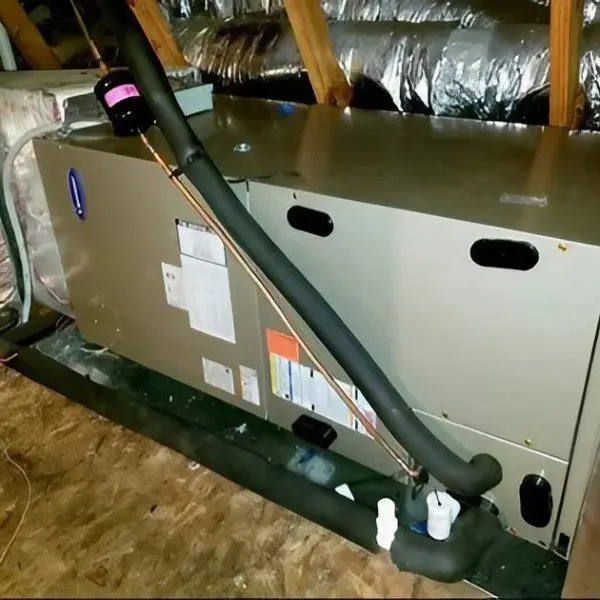 A large commercial air conditioner is being installed in the attic, with the technician ensuring proper placement and connections for optimal performance