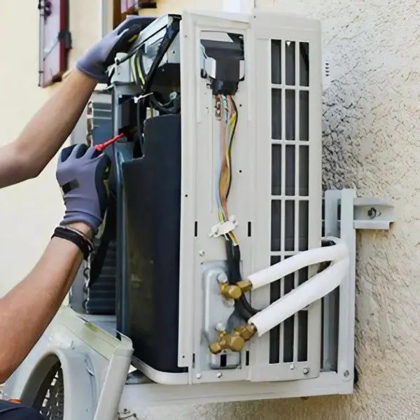 AC Professional Working on an Air Conditioner An AC professional is working on an air conditioner, performing maintenance or repairs to ensure the system operates efficiently