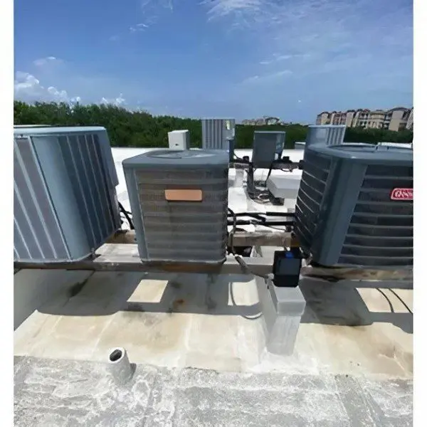 A view of several air conditioners installed on the roof of a commercial building, providing cooling for the space below