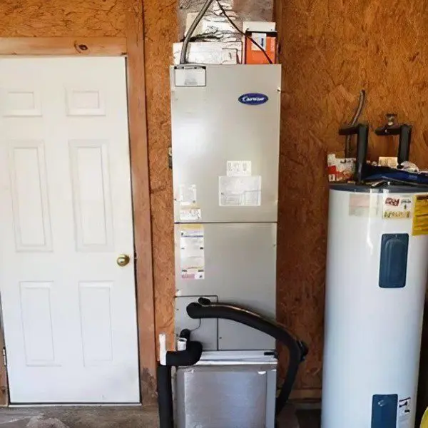 A Carrier air handler is installed in a garage, providing heating and cooling for the space