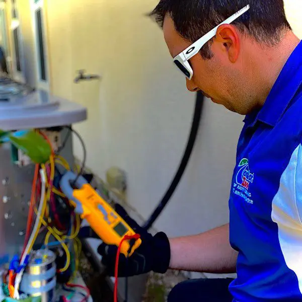 AC Technician Working on the Electrical System of an Air Conditioning Unit An AC technician is working on the electrical system of an air conditioning unit, performing repairs to ensure safe and efficient operation