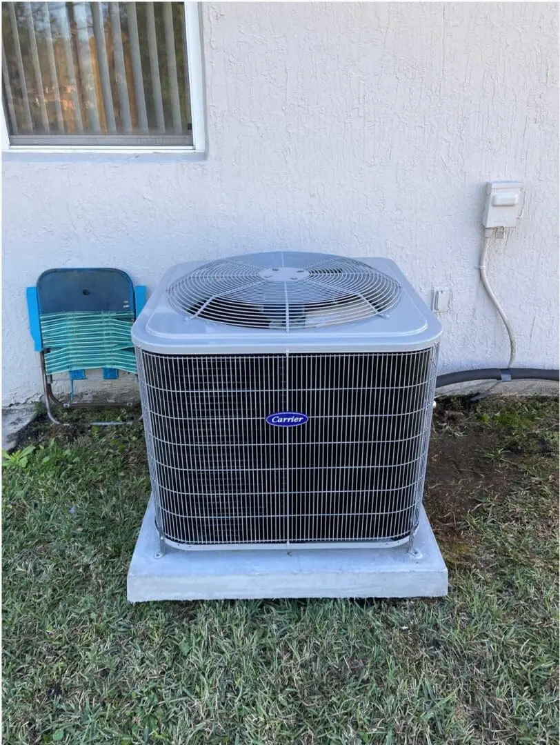 Large Air Conditioner Installed Outside a Home A large air conditioner is installed outside a house, placed on a concrete slab, ready for operation to cool the home efficiently