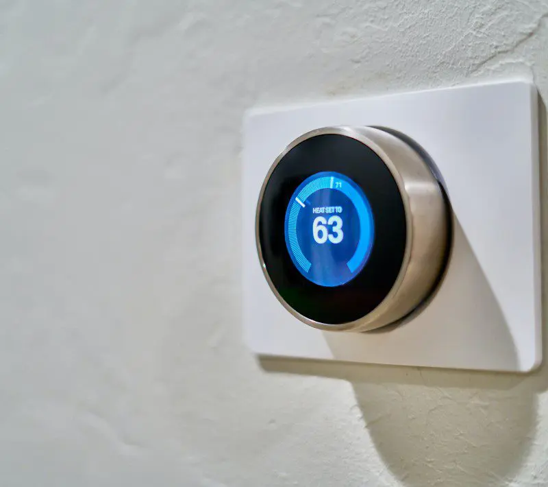 A smart nest thermostat is mounted on the wall.