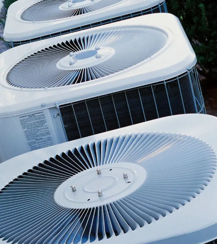 A row of air conditioners sitting on top of each other.