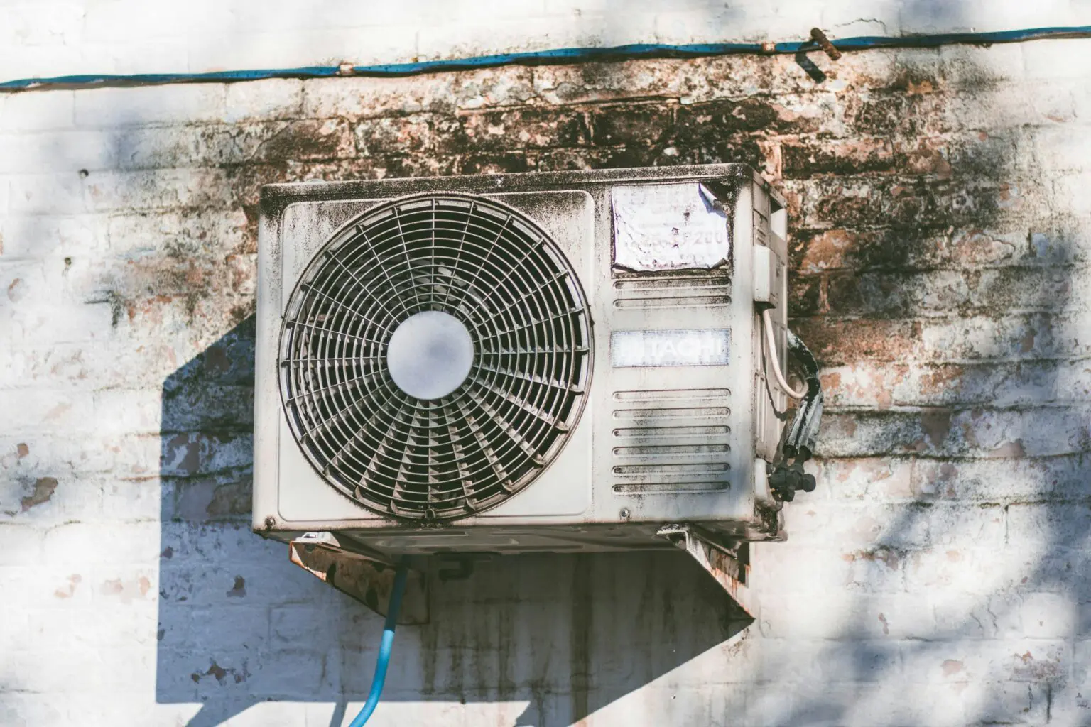 Dirty Air Conditioner Mounted on the Side of a Building A dirty air conditioner mounted on the side of a building, with visible dirt and grime that may reduce its cooling performance