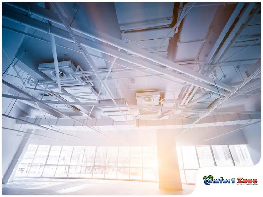 Air conditioners are located in the ceiling of a large commercial room, providing cooling throughout the space