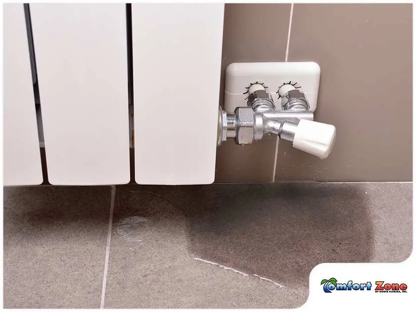 AC Leaking Water onto the Floor An AC Unit is leaking water onto the floor, indicating a potential issue such as a clogged drain or a malfunction in the unit