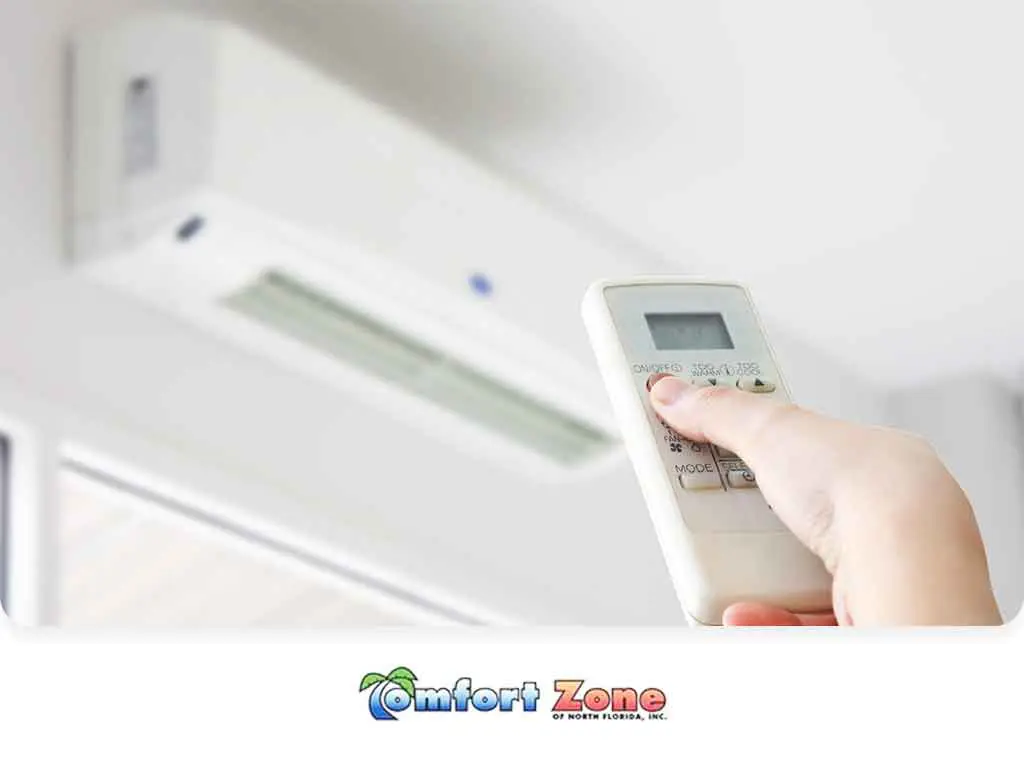 Homeowner Adjusting Mini Split Temperature with Remote Control A homeowner is adjusting the temperature of a mini split air conditioning system using a remote control, customizing the indoor climate for comfort