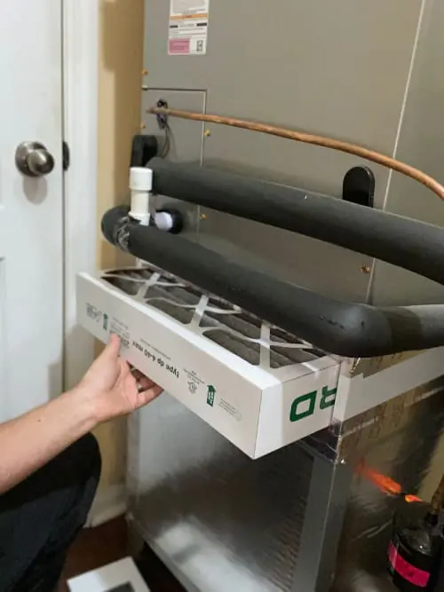A technician is replacing an air conditioning filter in a unit at a home in Fernandina Beach, Florida, ensuring proper airflow and system efficiency