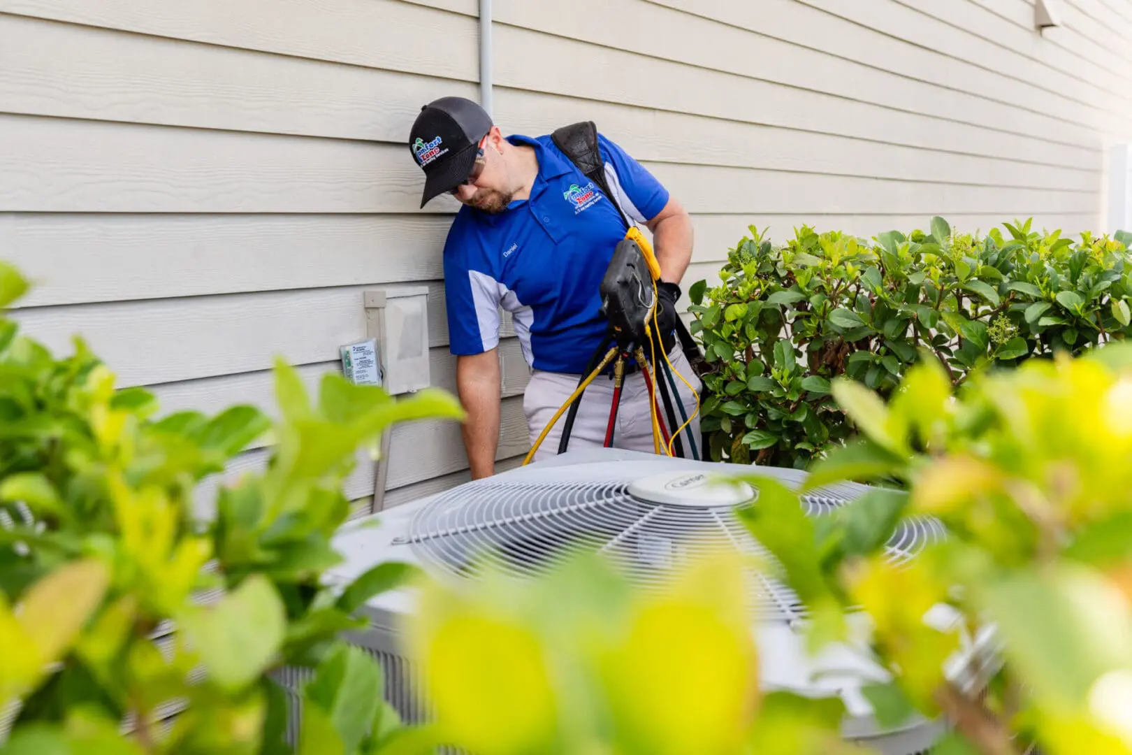 An expert HVAC technician is carefully inspecting and analyzing a heat pump system outside a home in Yulee, Florida, using diagnostic tools to ensure proper operation.