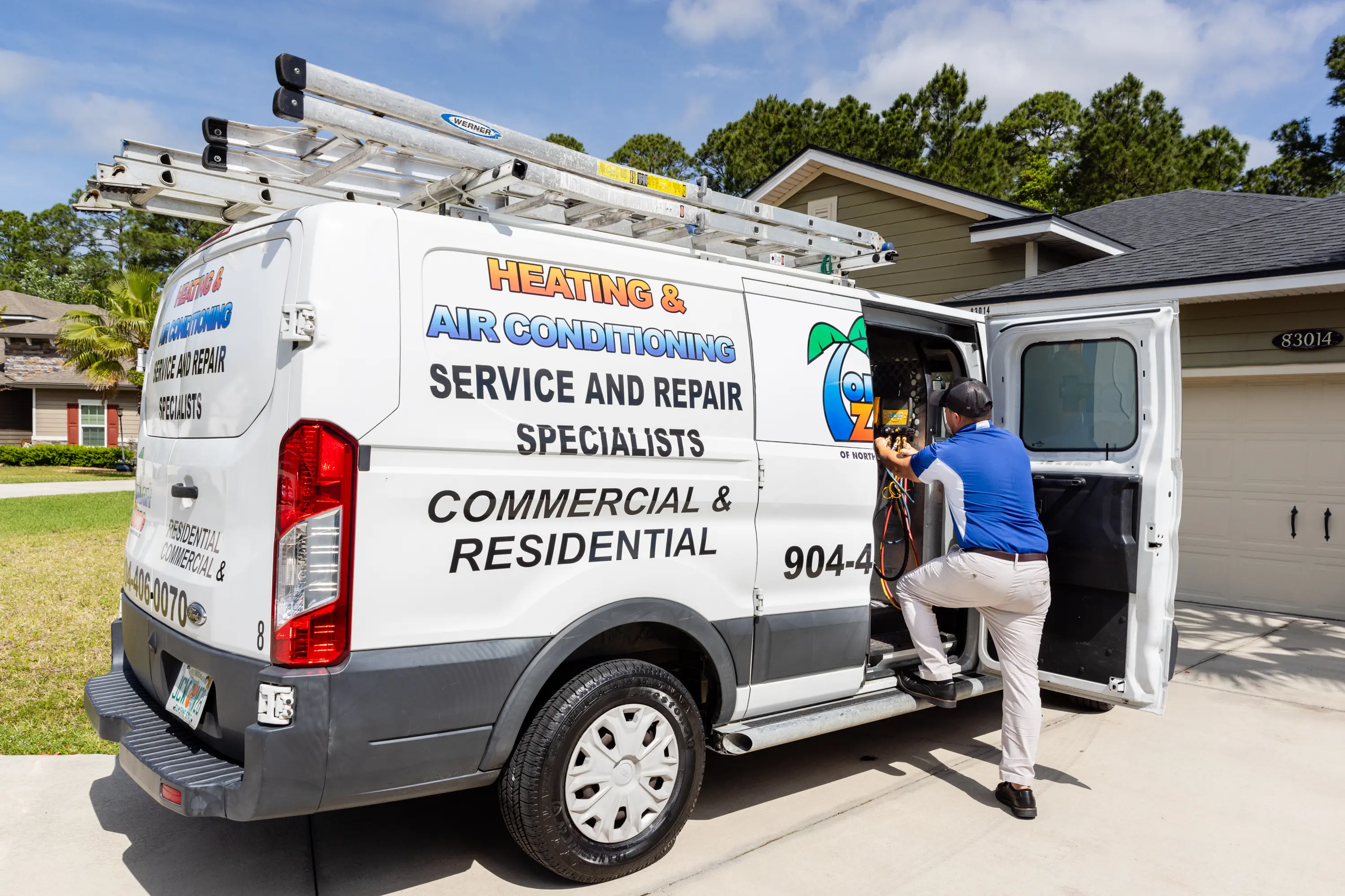 HVAC Technician Loading Equipment into Company Service Van A professional HVAC technician is loading equipment and tools into the back of a company service van, preparing for the next service call.