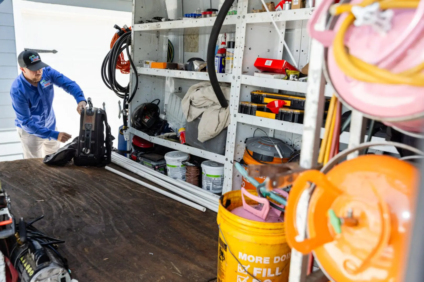 A Air Conditioning Repair Technician is standing in front of some tools to service an AC.