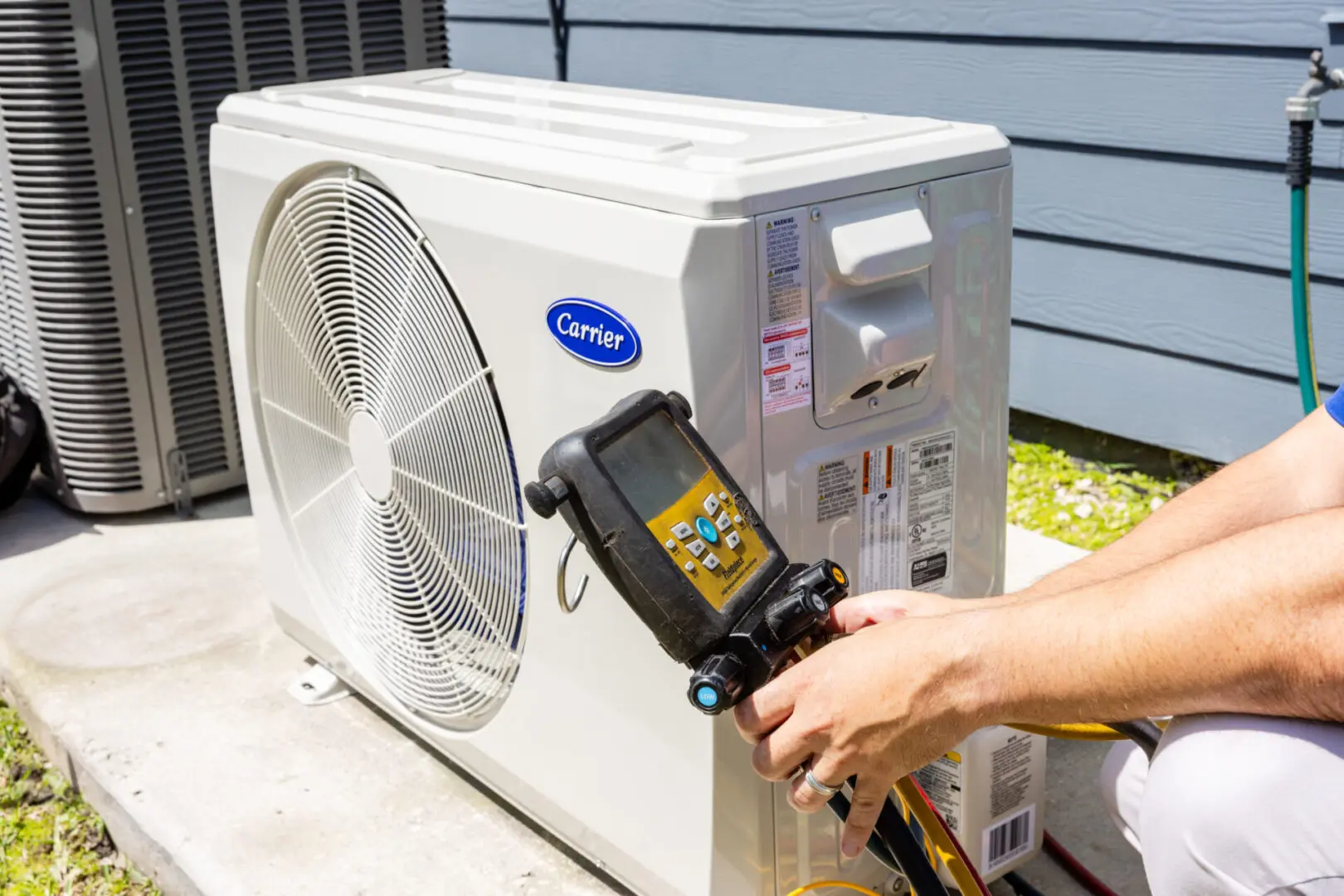 An AC Repair Service man is using an air conditioner tool to cool it.