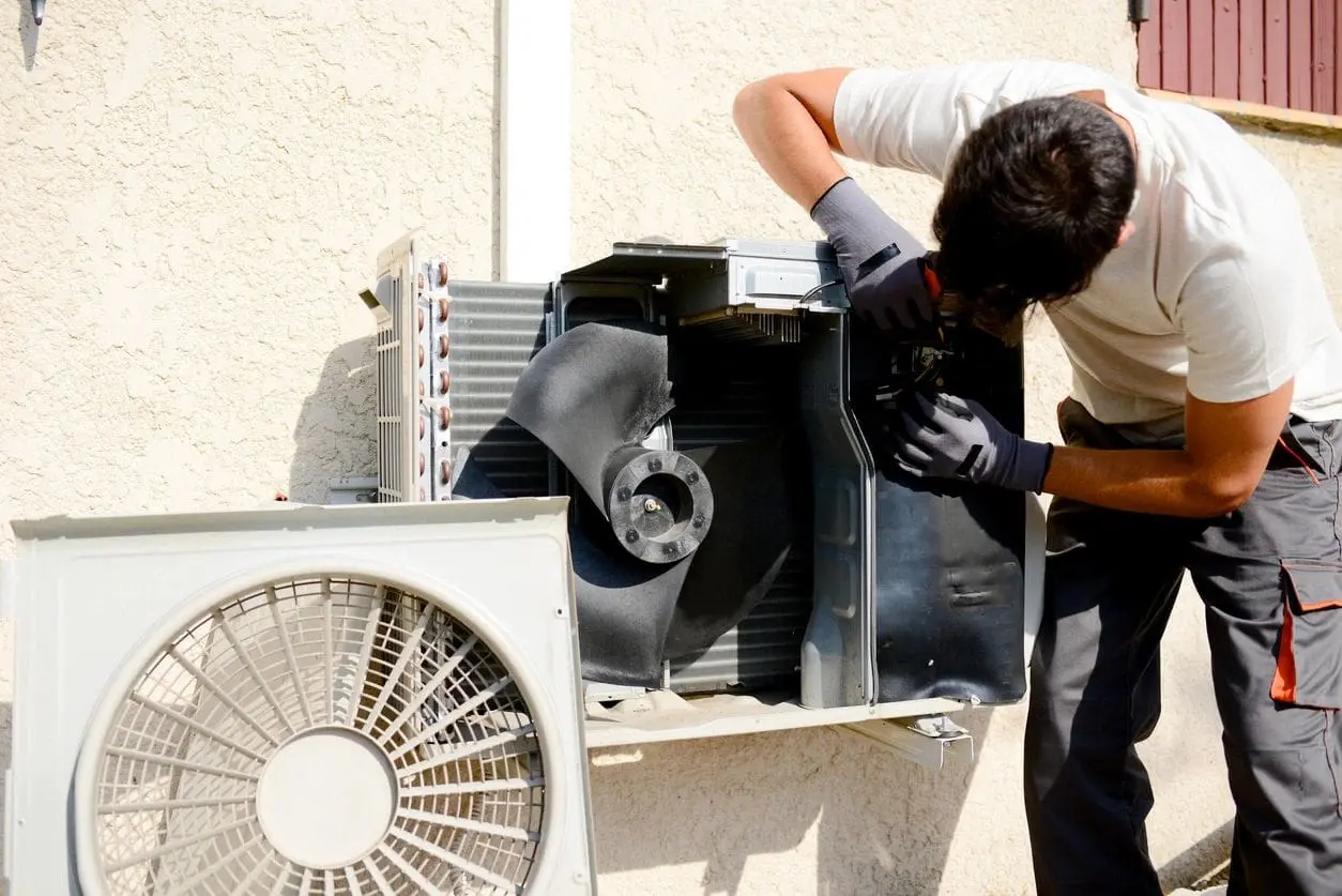Air conditioning man repairing an electrical component on a ductless mini split unit