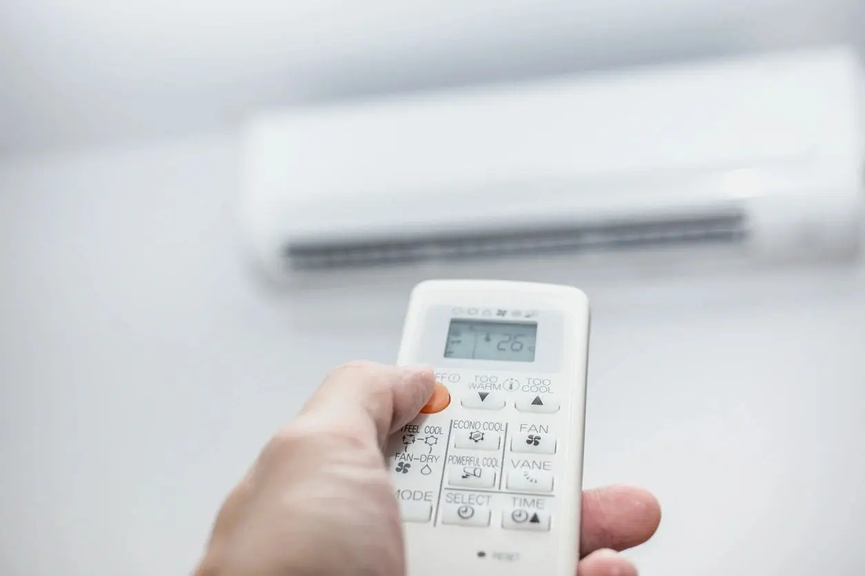 Customer adjusting temperature for a ductless mini split hanging on the wall of a residential home