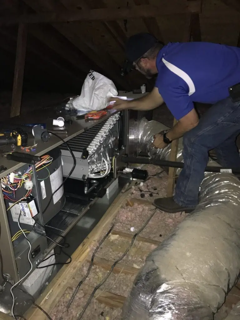 AC tech servicing an air conditioning system in the attic, ensuring optimal performance and comfort for a Jacksonville home.