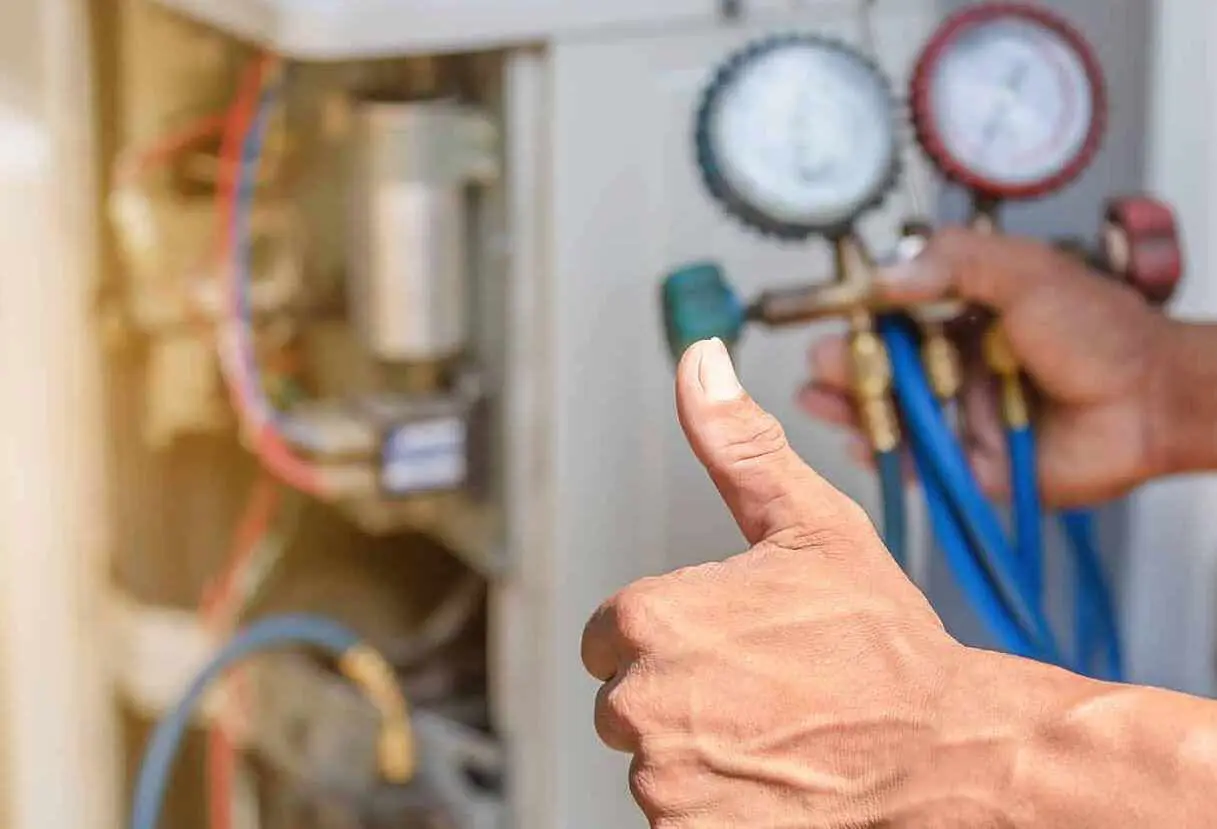Thumbs-up near HVAC refrigerant gauges and hoses