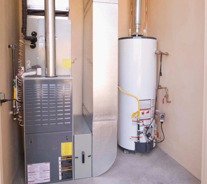 A water heater and furnace in a utility room.