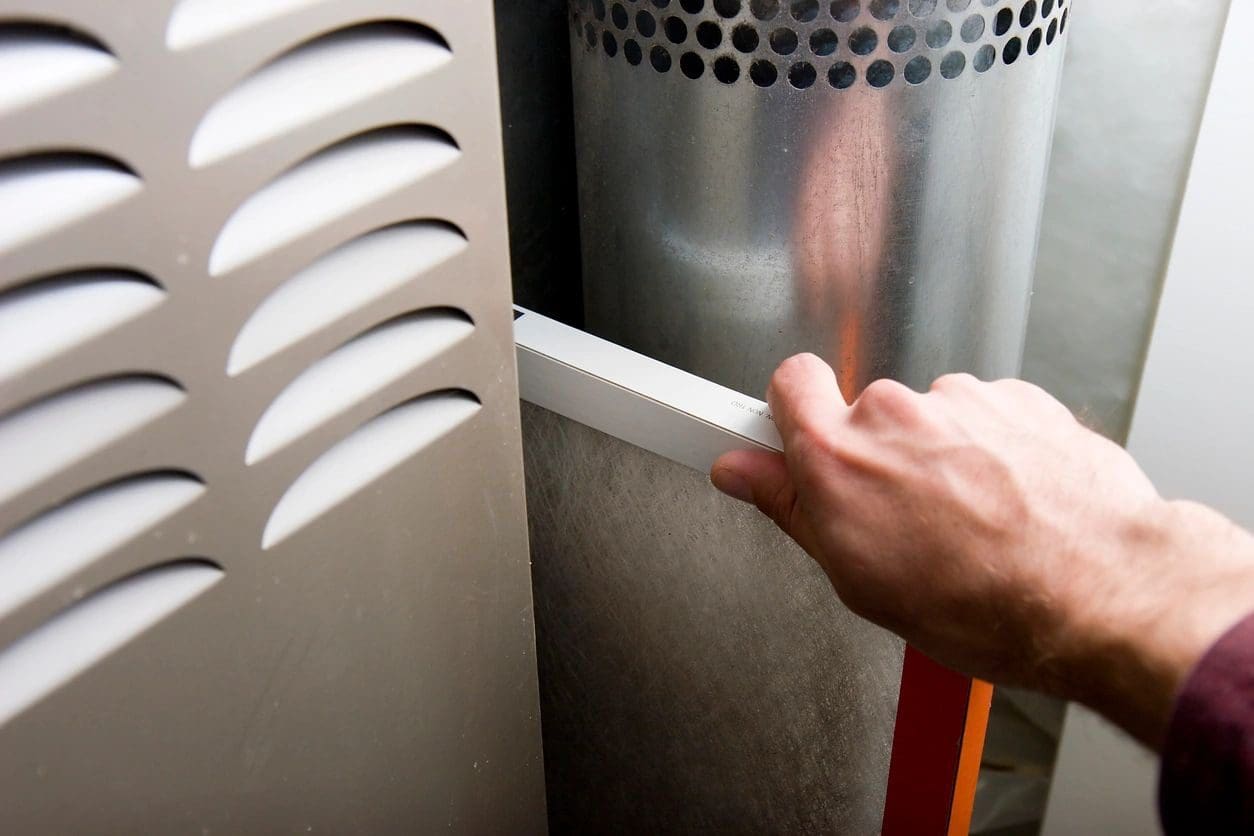 A person is holding the handle of an air conditioner.