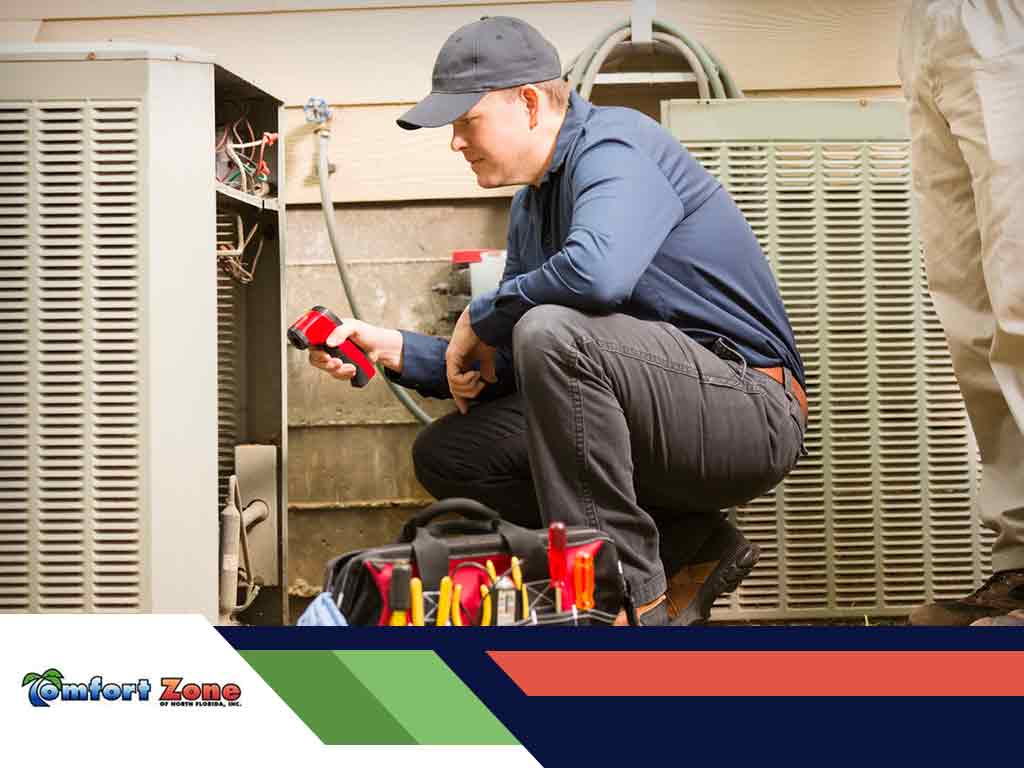 A technician repairs an hvac unit, equipped with tools, focused on fixing the equipment indoors.