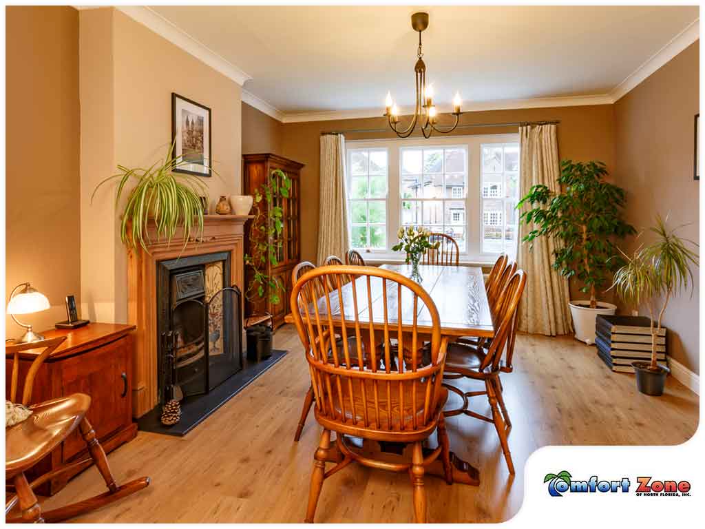 A dining room with wooden chairs and fireplace.