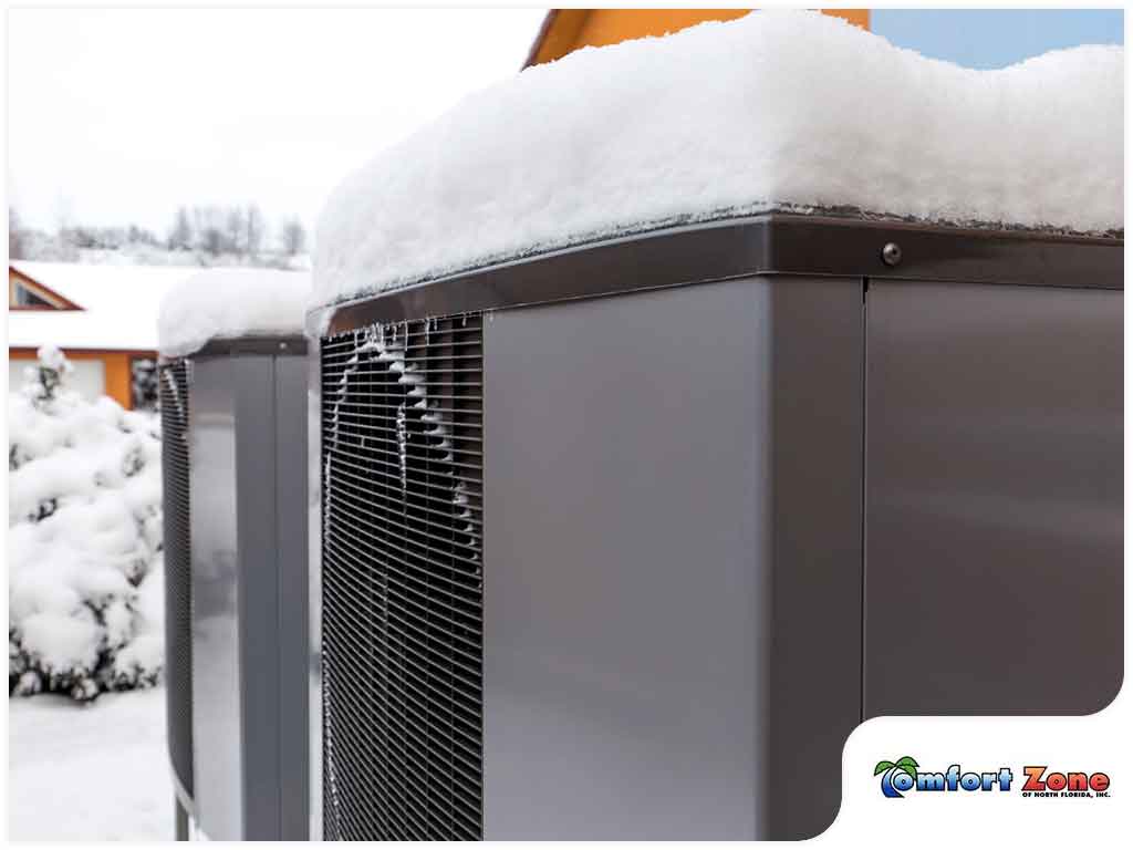 A close up of an air conditioner unit covered in snow.