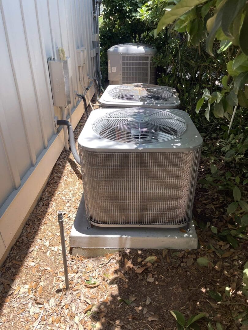 A couple of air conditioners sitting on top of concrete hurricane pads in Jacksonville