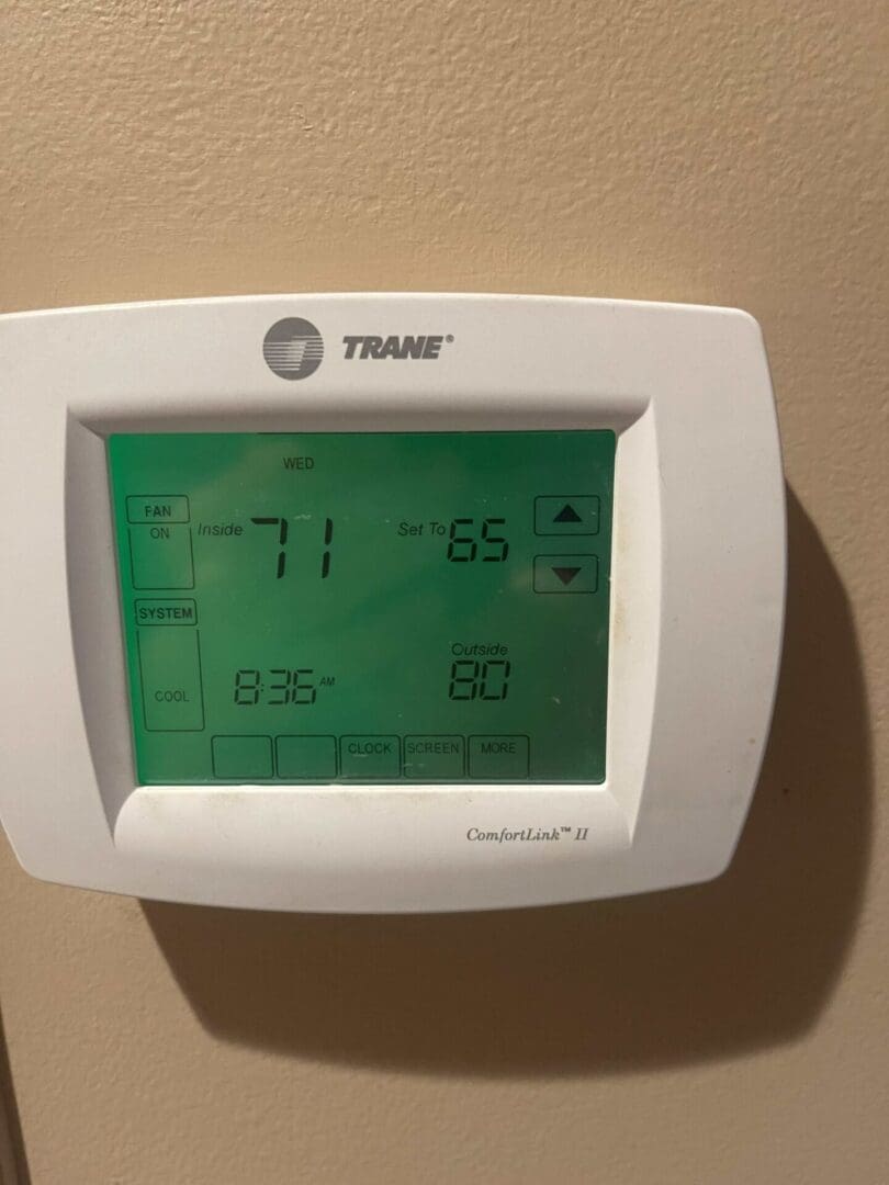 A digital thermostat is shown on the wall.