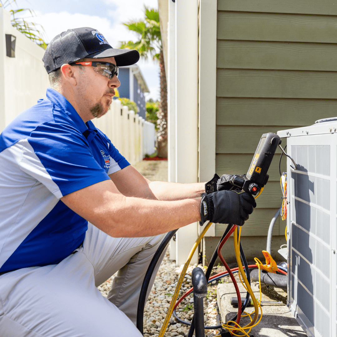 Technician servicing outdoor air conditioning unit.