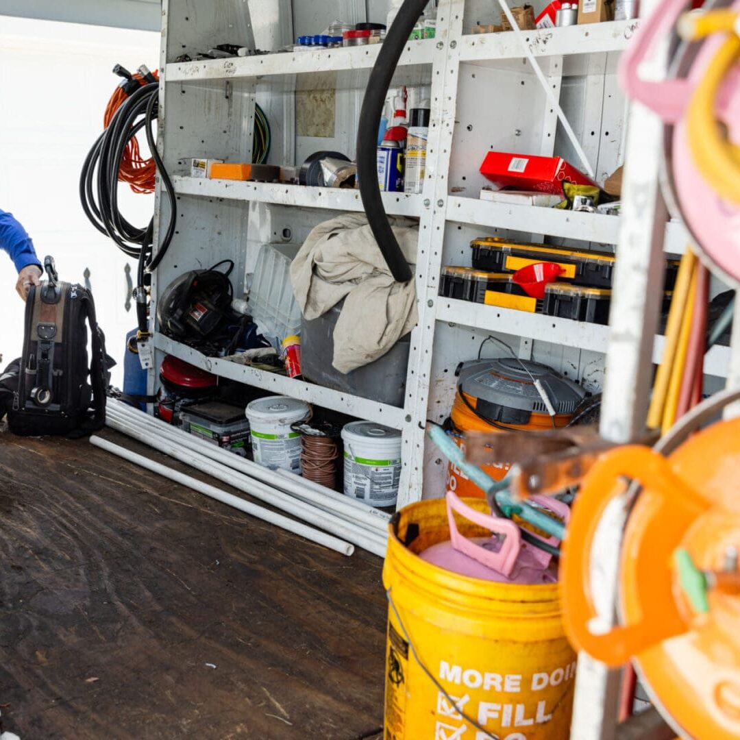 A Air Conditioning Repair Technician is standing in front of some tools to service an AC. A Air Conditioning Repair Technician is standing in front of some tools to service an AC.