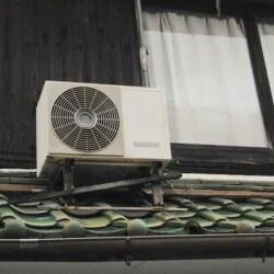 A small air conditioner on the side of a house.