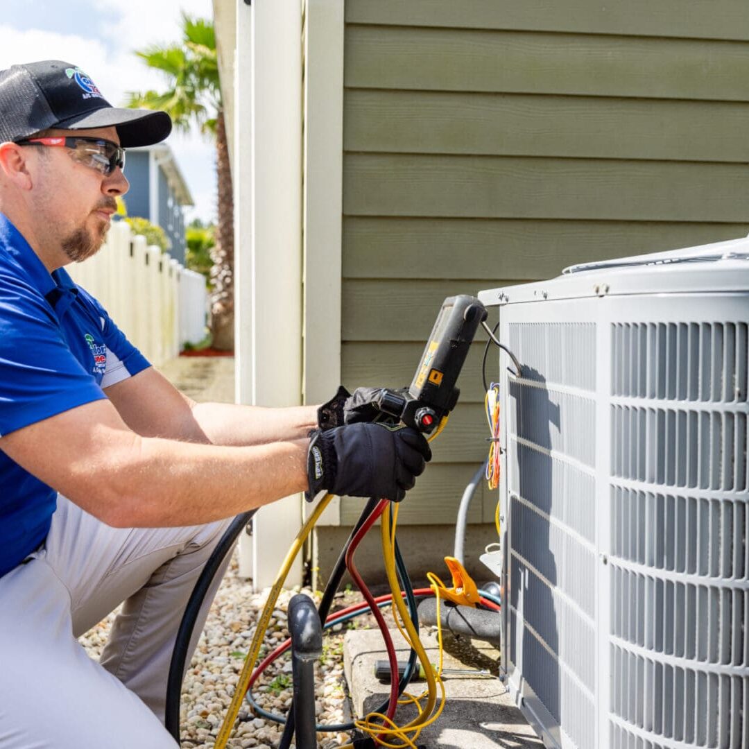 An air conditioning service technician is inspecting an outdoor air conditioning unit in front of a residential home in Yulee, Florida, ensuring the system is functioning properly. An air conditioning service technician is inspecting an outdoor air conditioning unit in front of a residential home in Yulee, Florida, ensuring the system is functioning properly.