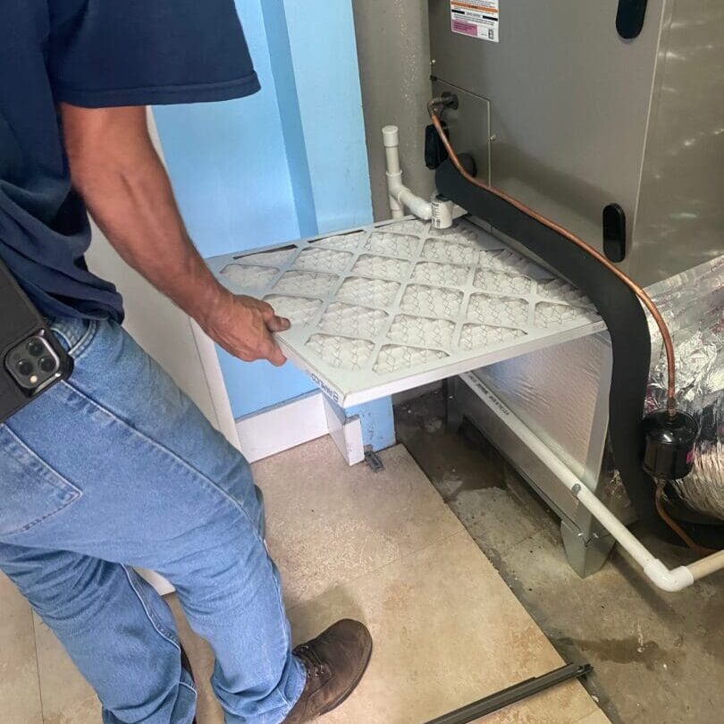 An HVAC service technician is installing a new air filter in an air conditioning unit in Wildlight, Florida, ensuring proper filtration for efficient system operation An HVAC service technician is installing a new air filter in an air conditioning unit in Wildlight, Florida, ensuring proper filtration for efficient system operation