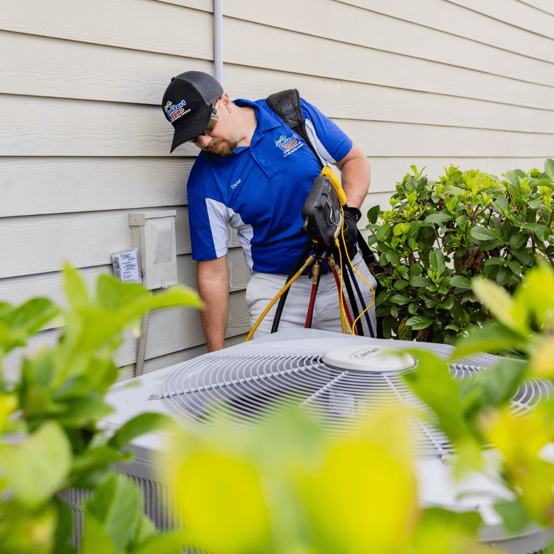 Technician inspecting air conditioning unit outside.