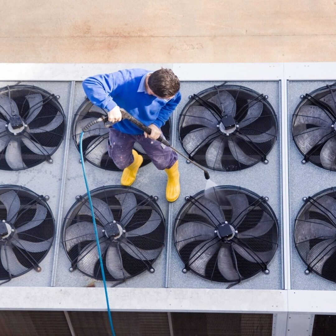 A air conditioning maintenance technician is cleaning the air conditioning units. A air conditioning maintenance technician is cleaning the air conditioning units.