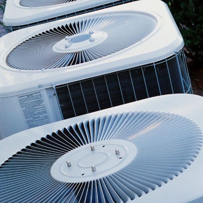 A row of air conditioners sitting on top of each other.