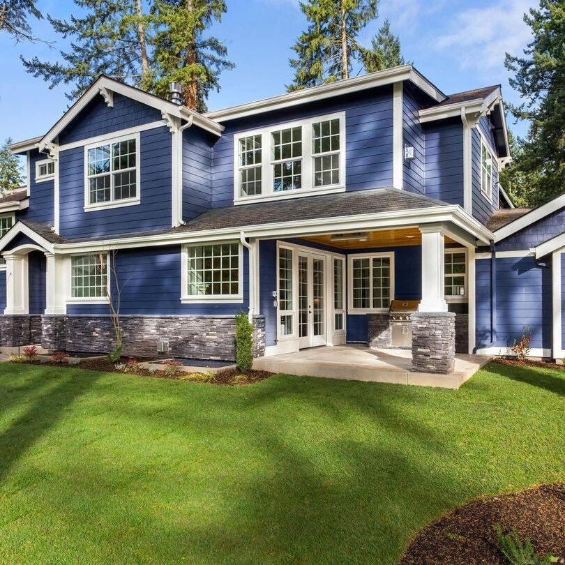 A blue house with white trim and green grass. A blue house with white trim and green grass.